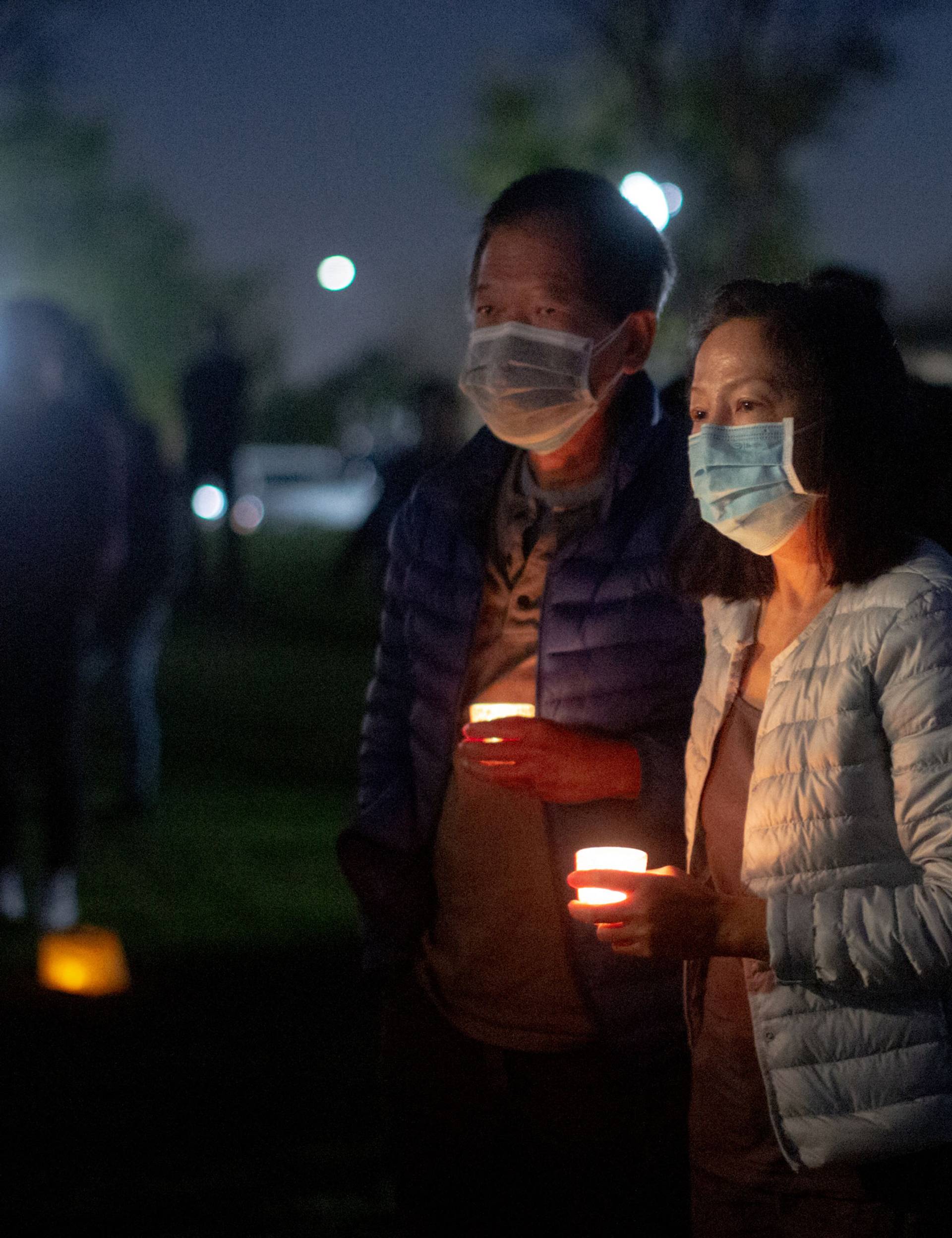 Dr. Mai Khanh Tran, center, stands with her husband, Manh Phi, while mourning at a vigil for those who lost their lives in the Atlanta spa shootings, at Community Center Park in Garden Grove, California, on March 24, 2021. Dr. Tran, a pediatrician, has been active in the fight against anti-Asian hate and has seen it continue to get worse through the years.