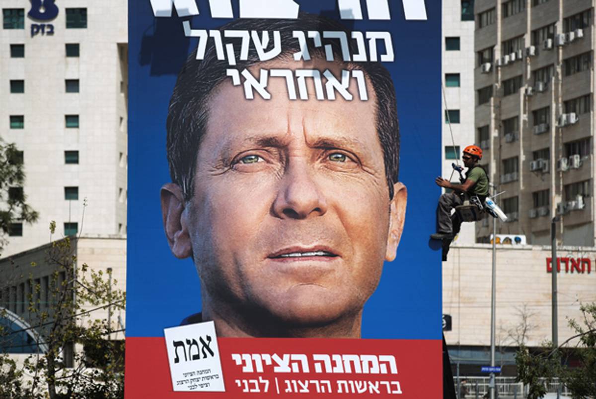 Workers hang a campaign poster of Labor Party leader Isaac Herzog on March 11, 2015 in Jerusalem. (MENAHEM KAHANA/AFP/Getty Images)