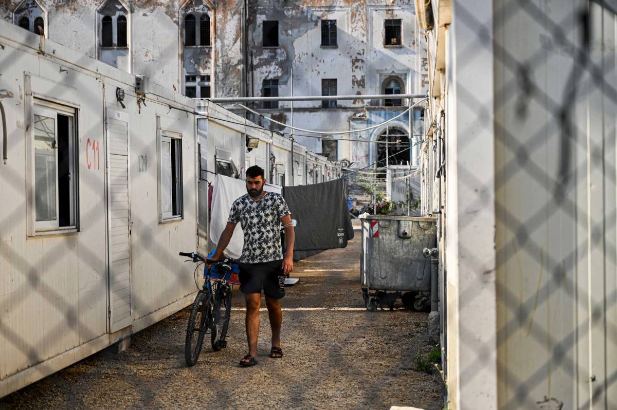 A migrant pushes a bike inside the migrant camp on the Greek island of Leros, on Sept. 8, 2021