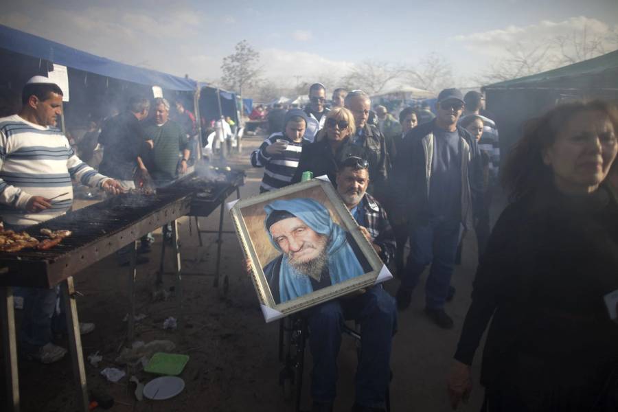 A man carries a portrait of Rabbi Baba Sali at his tomb compound during the annual pilgrimage to his grave in the southern Israeli town of Netivot 