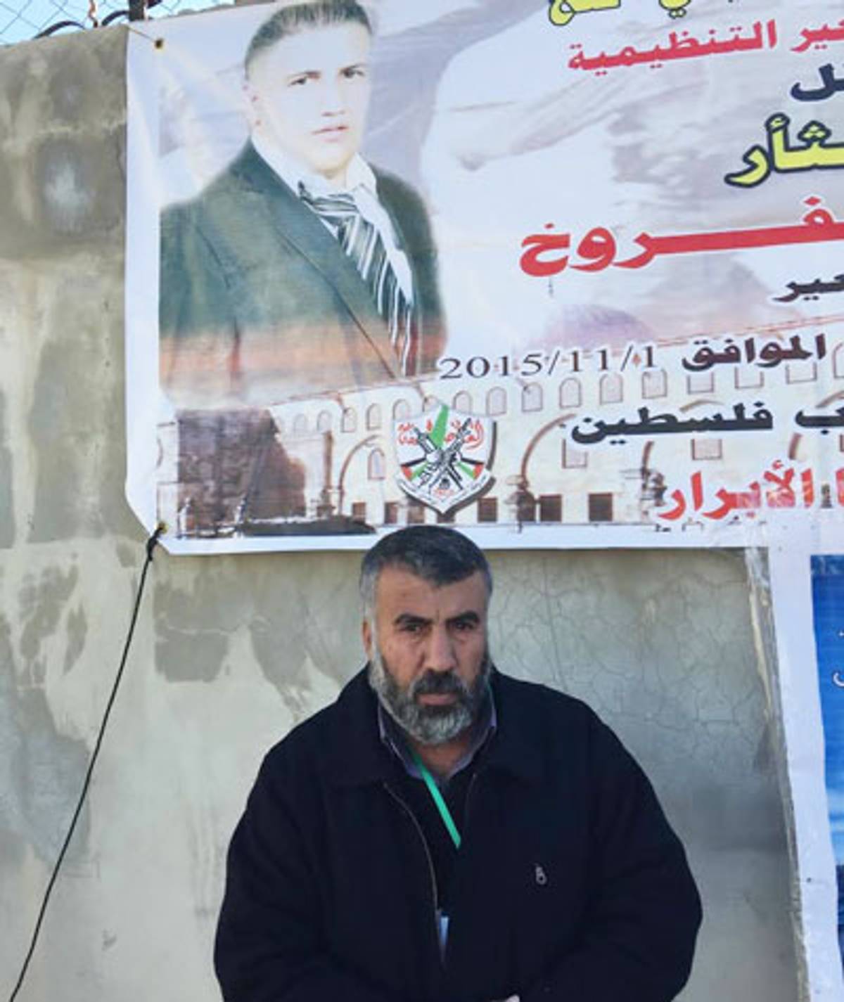 Hassan Faroukh stands next to a banner displaying his son, Fadi, 27, killed while trying to stab an Israeli soldier outside the village of Beit Anoun on Nov. 1, 2015. (Photo: Elhanan Miller)