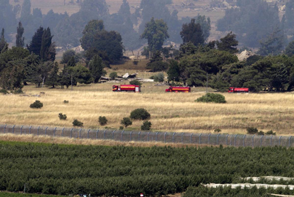 A picture taken on June 6, 2013 from the Israeli side along the Israel-Syria ceasefire line in the Golan Heights shows firefighting trucks driving after clashes between Syrian rebels and forces loyal to the regime caused fire near the Quneitra crossing. (AHMAD GHARABLI/AFP/Getty Images)