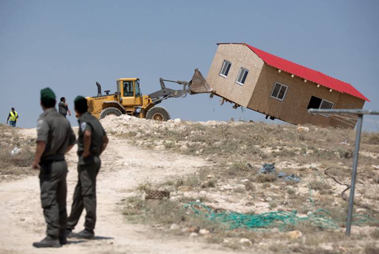An Israeli authority bulldozer demolishes a house in the West Bank settlement of Maale Rehavam on May 14, 2014. (MENAHEM KAHANA/AFP/Getty Images)