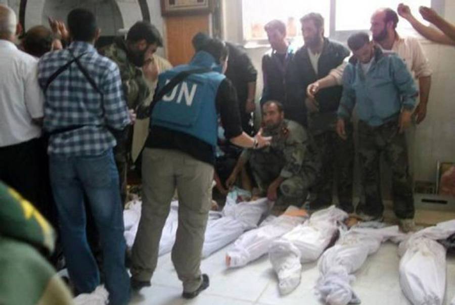 U.N. monitors view bodies in Houla.(AFP/Shaam News Network)