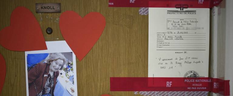 A picture taken on March 27, 2018 shows a picture of Mireille Knoll, heart-shaped documents and seals of the police posted on the door of her apartment in Paris after she was found dead in her apartment on March 23 by firefighters called to extinguish a blaze. Two people have been charged with the murder of an 85-year-old French Jewish woman, who was stabbed and whose body was then set alight in a crime being treated as anti-Semitic, a judicial source said on March 27, 2018.