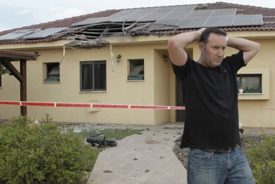 An Israeli Man in Southern Israel Stands Outside of His Home Following a Rocket Attack(Haaretz)