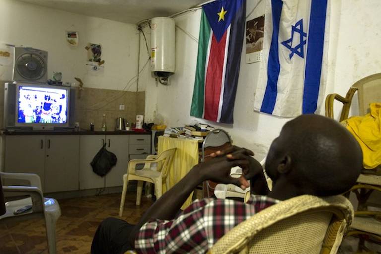 An African migrant from South Sudan watches television in Tel Aviv. (JACK GUEZ/AFP/GettyImages))