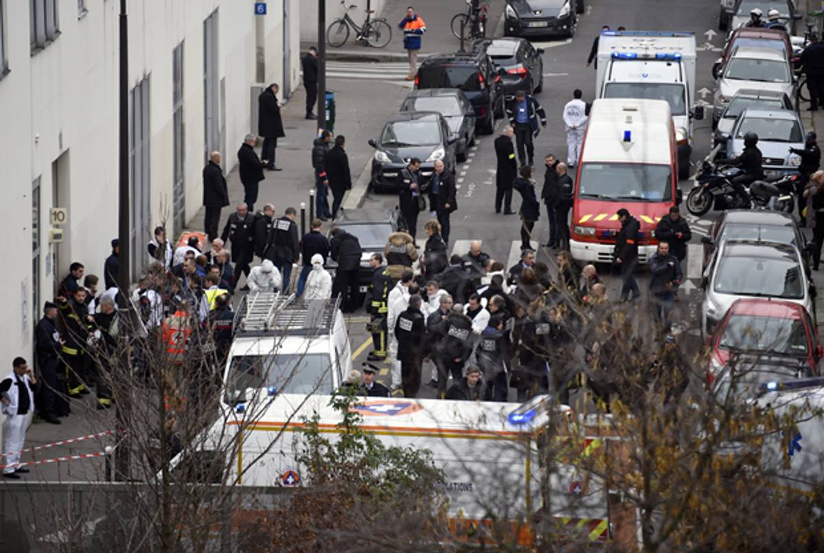 Firefighters, police officers, and forensics gathered in front of the offices of the French satirical newspaper Charlie Hebdo in Paris on January 7, 2015, after armed gunmen stormed the offices leaving 12 dead. (MARTIN BUREAU/AFP/Getty Images)