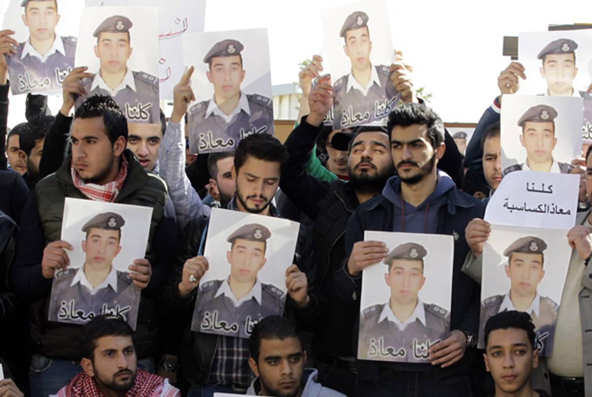 Activists hold posters with a portrait of the Jordanian pilot Maaz al-Kassasbeh, who was captured and reportedly killed by ISIS. (KHALIL MAZRAAWI/AFP/Getty Images)