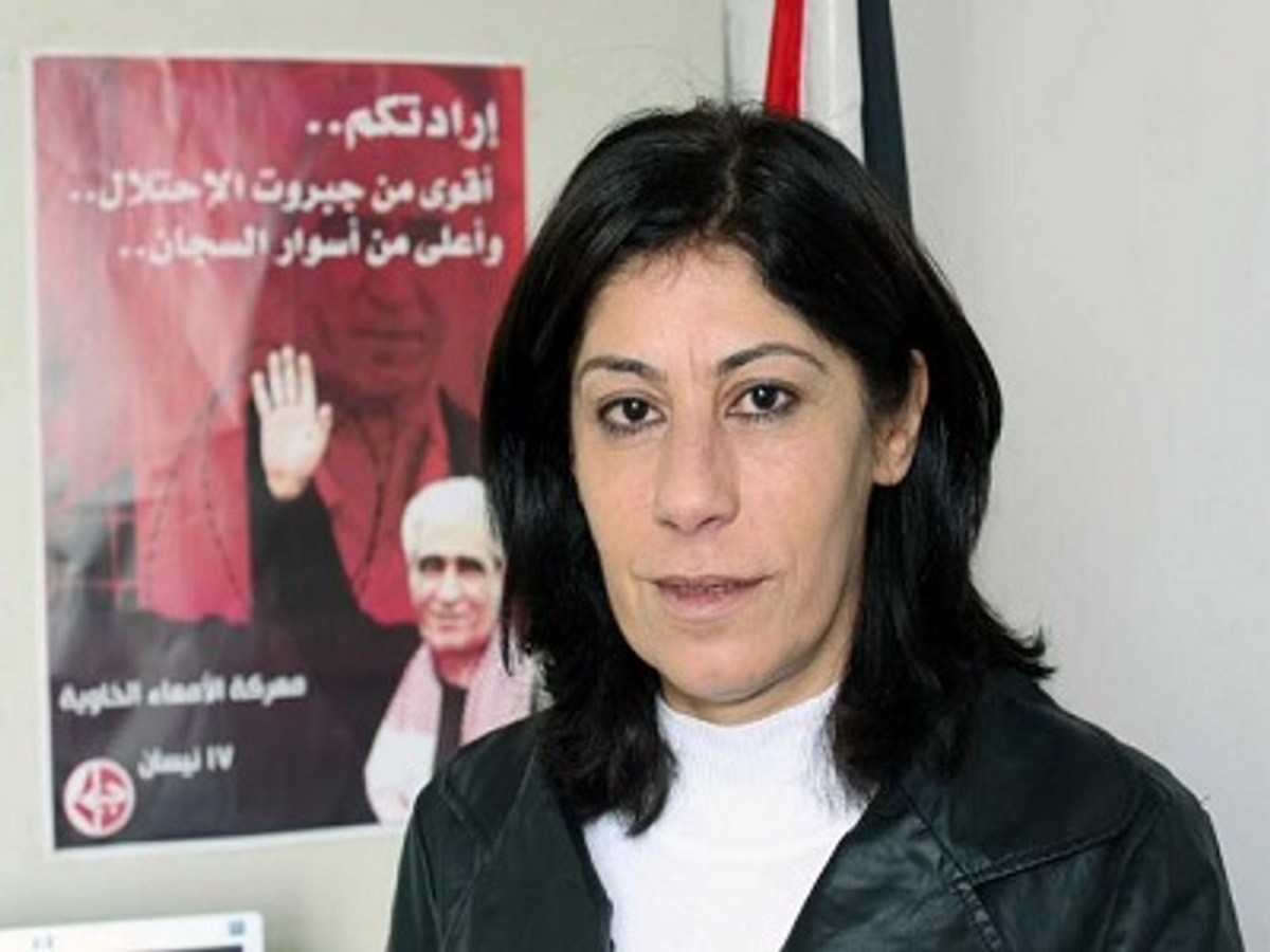 Khalida Jarrar posing with PFLP poster featuring the imprisoned terrorist Ahmad Sa’adat, convicted of plotting the 2001 murder of Israeli Tourism Minister Rehavam Ze’evi