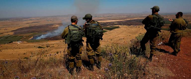 Israeli soldiers at an army base in the Israeli-annexed Golan Heights look out across the southwestern Syrian province of Quneitra, visible across the border on July 7, 2018.