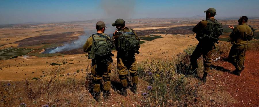Israeli soldiers at an army base in the Israeli-annexed Golan Heights look out across the southwestern Syrian province of Quneitra, visible across the border on July 7, 2018.