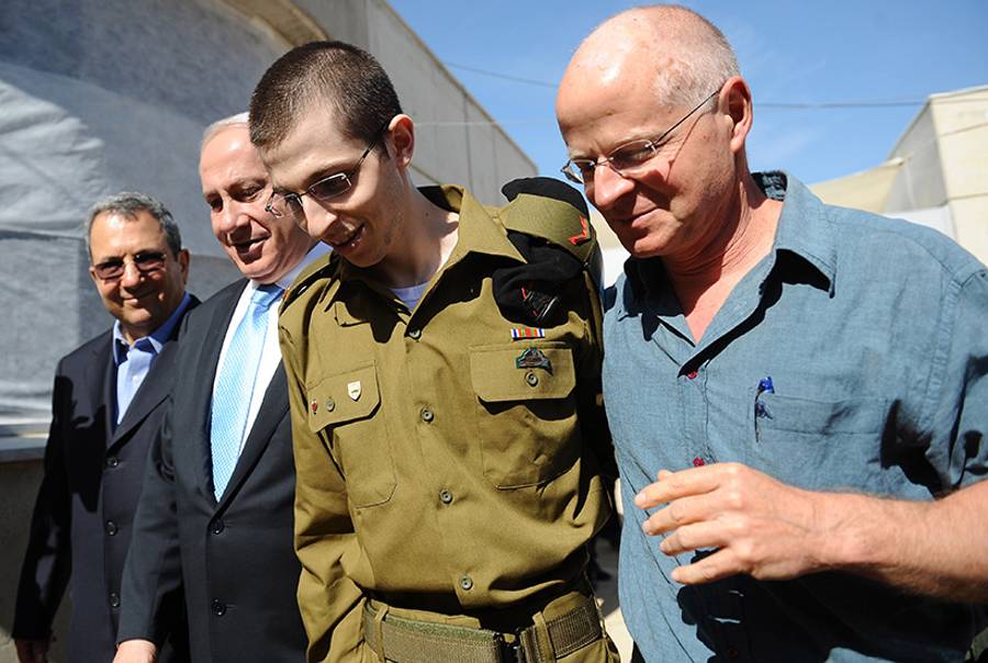 Freed Israeli soldier Gilad Shalit with Defense Minister Ehud Barak, Israeli Prime Minister Benjamin Netanyahu, and his father Naom Shalit at Tel Nof Airbase on Oct. 18, 2011, in central Israel.(IDF via Getty Images)