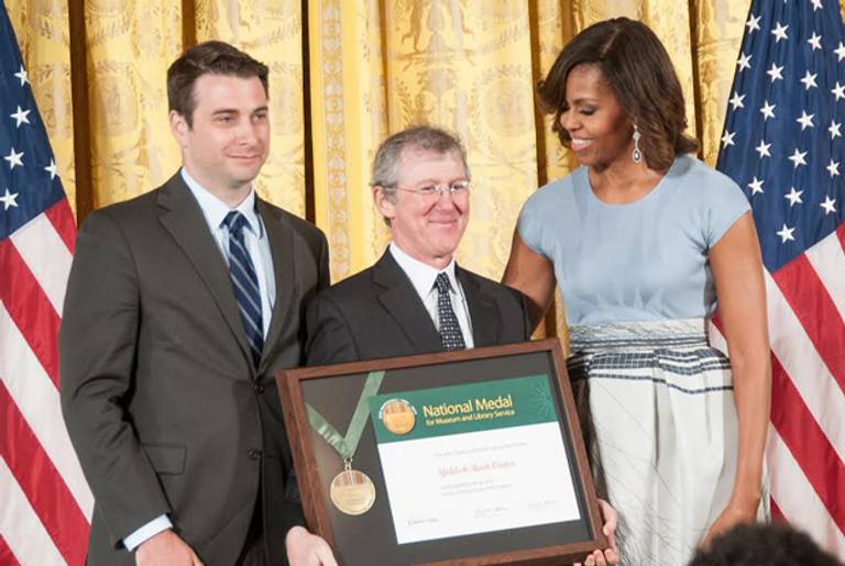 First Lady Michelle Obama presents the National Medal for Museum and Library Service to Yiddish Book Center community member Peter Manseau (L) and Founder and President Aaron Lansky (C).(Institute of Museum and Library Services (IMLS))