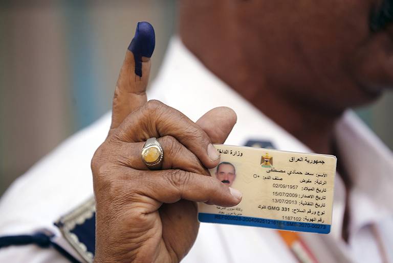 An Iraqi policeman shows his ink-stained finger and his ID after casting his ballot at a school in Baghdad's Karrada commercial district on April 28, 2014.(Sabah Arar/AFP/Getty Images)