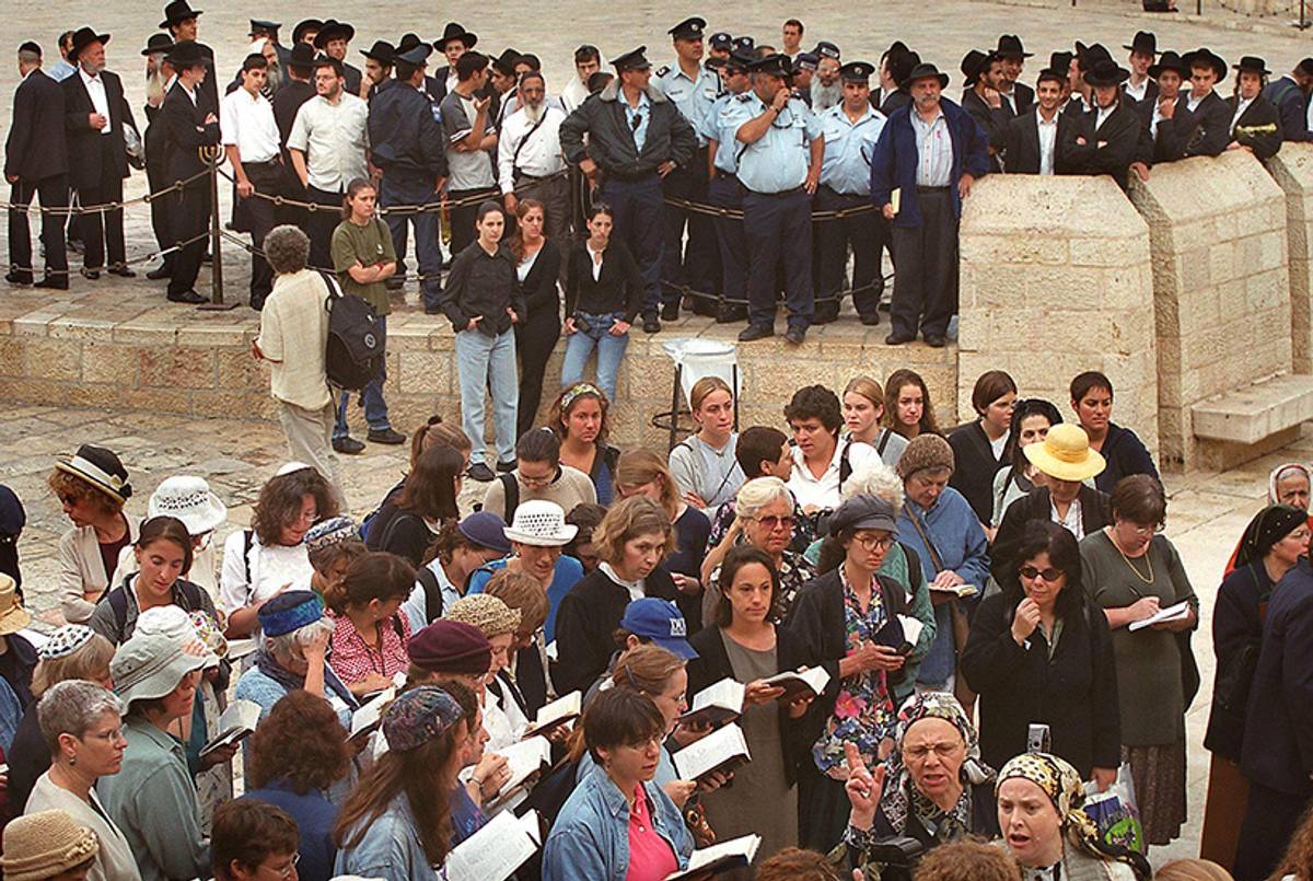 Conservative Jewish women hold a morning prayer at the Wall in Jerusalem's Old City on June 4, 2000, while ultra-Orthodox Jewish men and women voice their protests.(Menahem Kahana/AFP/Getty Images)