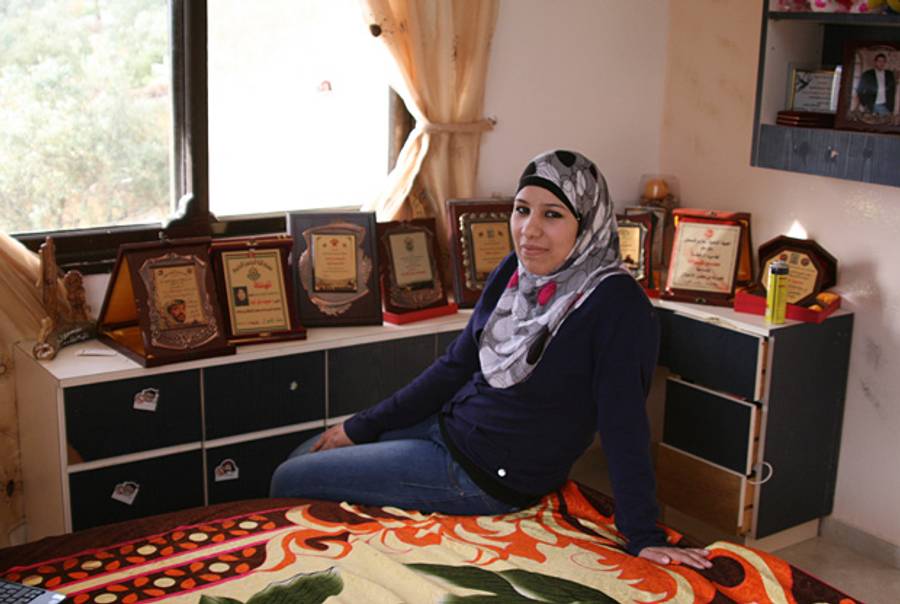 Sumoud Karajeh in her bedroom, surrounded by plaques celebrating her.(Daniella Cheslow)