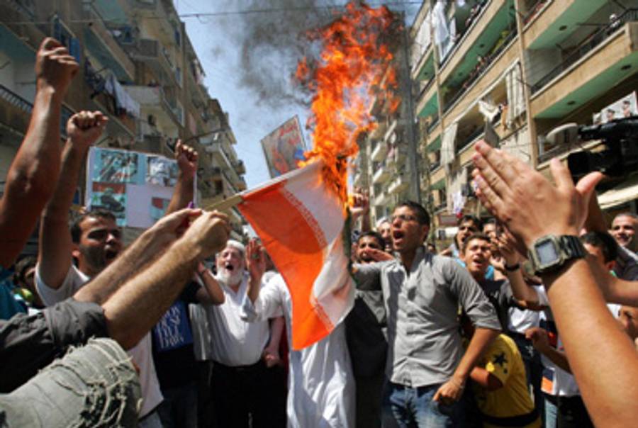 Anti-Assad demonstrators in Lebanon, near Syria, burn an Iranian flag over the weekend.(-/AFP/Getty Images))