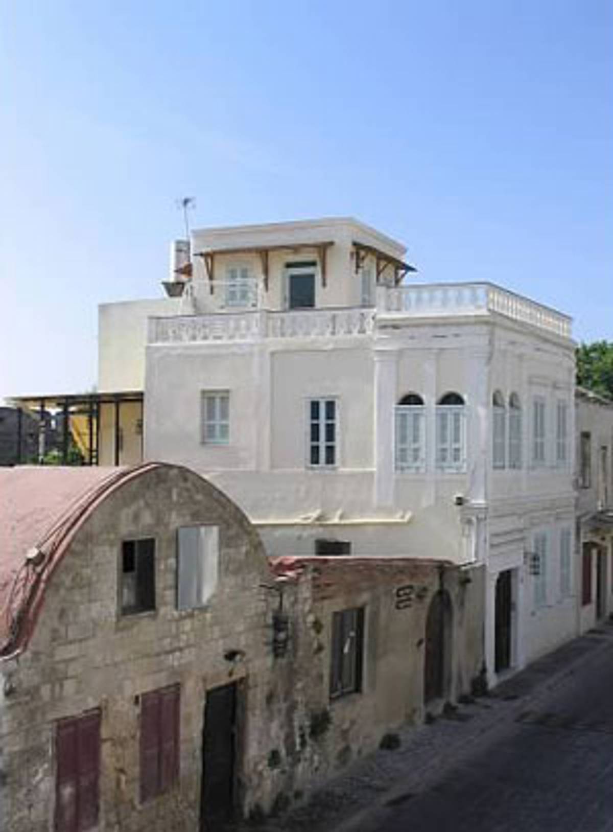 The tall white house on the righthand side of this photo is where Shmuel Leon and Rivca Alhadeff lived with their eight children in La Juderia, the Jewish quarter of Rhodes. The house withstood wartime bombings and still stands today.  (Photo: Hannah Pressman)