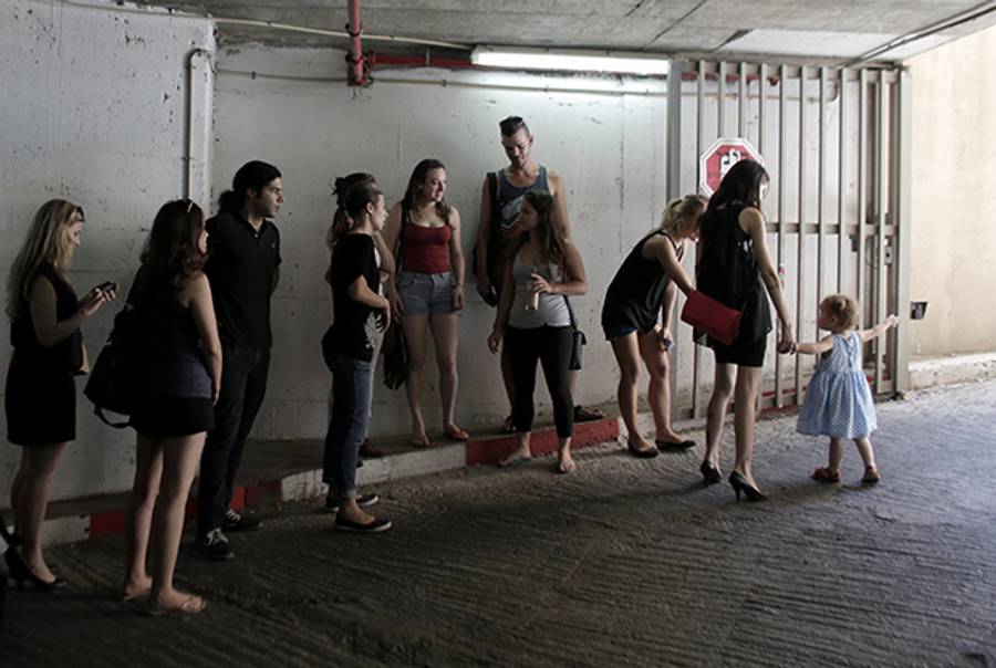 Israelis take cover in an underground car park in the city of Tel Aviv, on July 10, 2014, during a rocket attack by Palestinian militants from the nearby Gaza Strip. (AHMAD GHARABLI/AFP/Getty Images)
