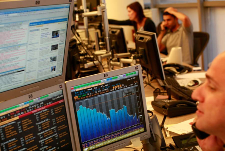 A trader looks at his monitors as he works in a dealing room in Tel Aviv on October 12, 2008 in Tel Aviv, Israel.(Photo by Uriel Sinai/Getty Images)