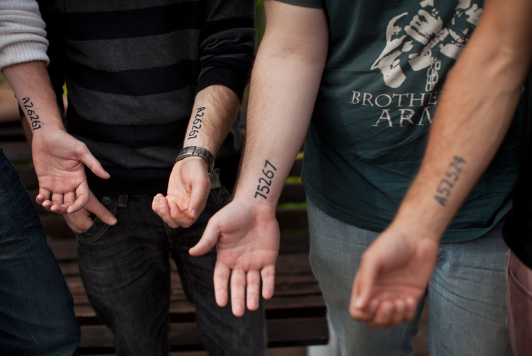 Jewish youths who have voluntarily tattooed their relative's Nazi concentration camp numbers on their forearms.