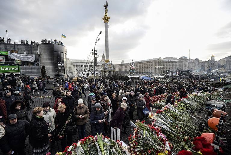 People lay flowers for and mourn the anti-government protesters who were killed in the past weeks' clashes with riot police, at a makeshift memorial on Kiev's Independence Square on Feb. 24, 2014.(Bulent Kilic/AFP/Getty Images)
