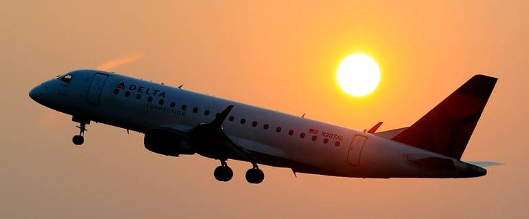 A Delta airline's aircraft takes off from the Ronald Reagan National airport as the sun rises in Washington, DC, June 9, 2011. 