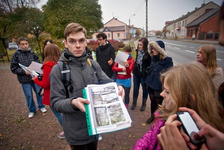 A high-school student holds pictures of vestiges of Jewish monuments on Nov. 2, 2011, in Konskie. Volunteers from the Forum for Dialogue Among Nations hold meetings and workshops aimed at discovering the lost Jewish heritage.(Wojtek Radwanski/AFP/Getty Images)