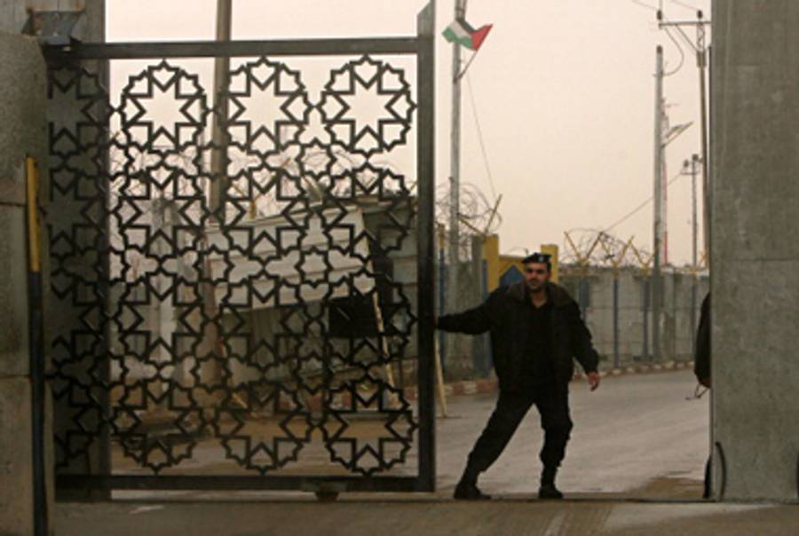 A Hamas security agent closes a border crossing between Egypt and the Gaza Strip on Sunday.(Said Khatib/AFP/Getty Images)