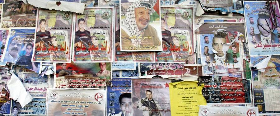 A portrait of Yasser Arafat is displayed on a wall together with Palestinian 'martyrs' pictures 11 November 2004 in the West Bank town of Nablus after the news of the veteran Palestinian leader's death spread.