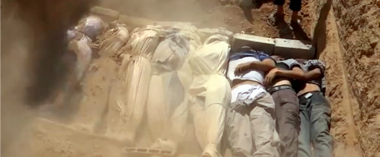 Screenshot from a video uploaded on YouTube by the Local Committee of Arbeen on Aug. 21, 2013, allegedly shows Syrians covering a mass grave containing bodies of victims that Syrian rebels claim were killed in a toxic gas attack by pro-government forces in eastern Ghouta and Zamalka, on the outskirts of Damascus.  