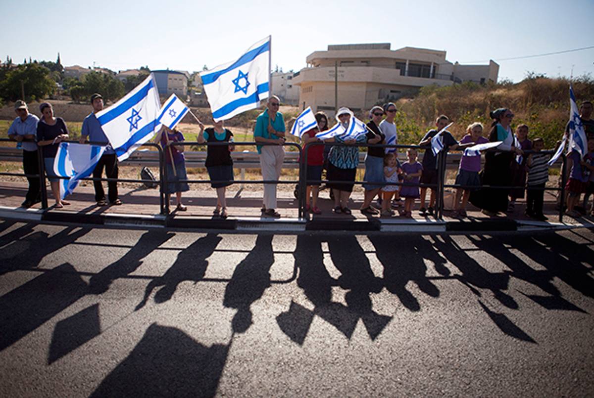 Israelis hold Israeli flags along the road of the funeral procession of Gilad Shaer, 16, one of three Israeli teens kidnapped on June 16, 2014. ( Lior Mizrahi/Getty Images)