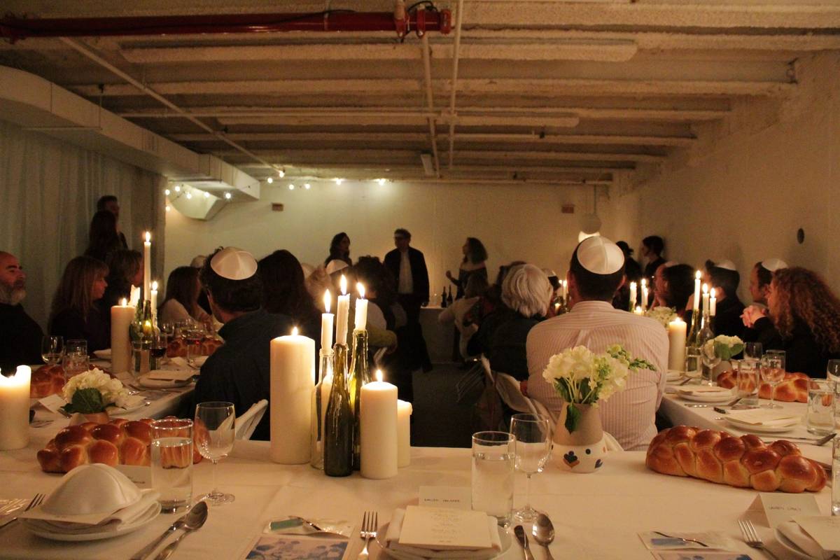 Guests gather around the dinner table for Jewish Food Society’s French-Polish Shabbat dinner celebrating Anna and Claude Polonsky’s culinary heritage at Ostudio in Brooklyn, New York, Jan. 31 2020