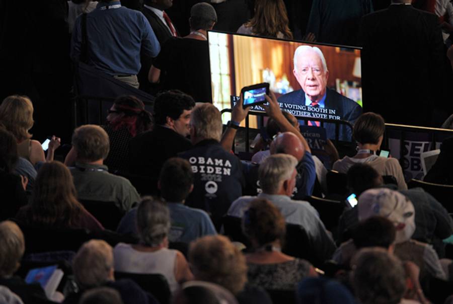 Supporters take pictures of the giant screen projecting a video address by former President Jimmy Carter on September 4, 2012 at the Democratic National Convention.(MLADEN ANTONOV/AFP/GettyImages)