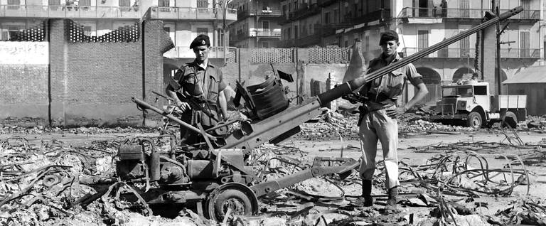 Picture released on November 1956 of soldiers standing among ruins and destroyed canon, in Port Said, Egypt, during the Suez crisis.