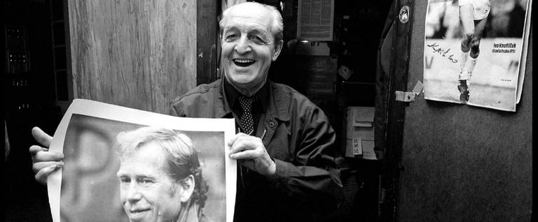 An employee in the Prague Jewish community center, December 1989, with a poster of dissident playwright, and soon to be president, Vaclav Havel. The poster reads 'HAVEL NA HRAD,' or Havel to the Castle (the president’s palace).