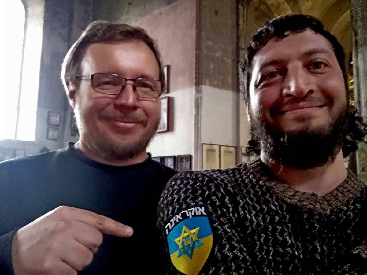 With Volodymyr Chistilin, a Ukrainian journalist and civil-society activist, in the Church of St. John the Theologian in Kharkiv in April. Zakharov's patch, worn by Israeil volunteers in Ukraine, shows the Ukrainian coat of arms inside a Star of David, and says, in Hebrew, 'Ukraine'