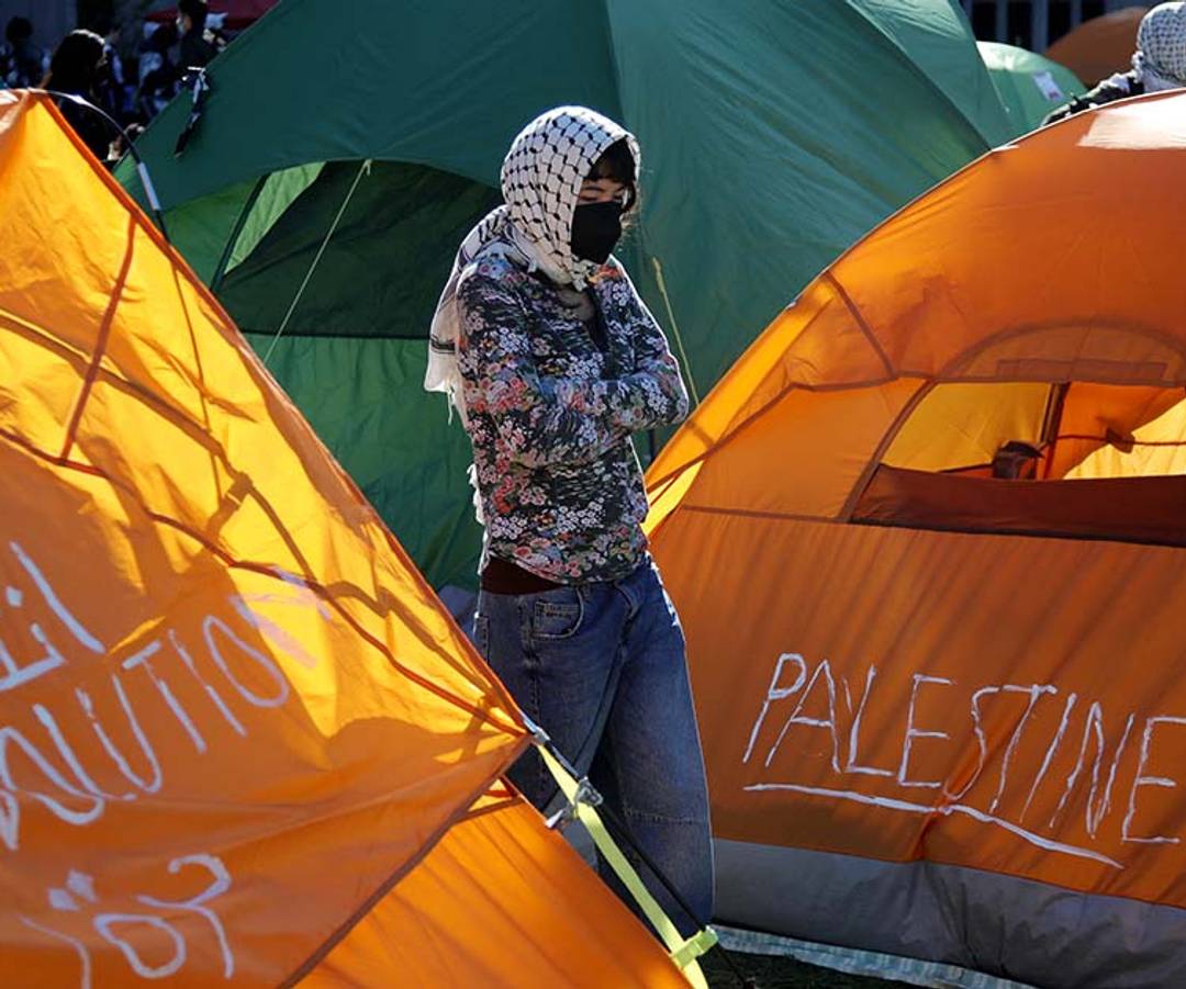 A person stands among tents at an encampment set up by pro-Palestinian protesters on the campus of Columbia University in New York on April 25, 2024