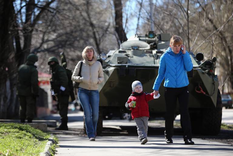 Members of the public walk past a Russian military personnel carrier outside a Ukrainian military base on March 17, 2014 in Simferopol, Ukraine. (Dan Kitwood/Getty Images)