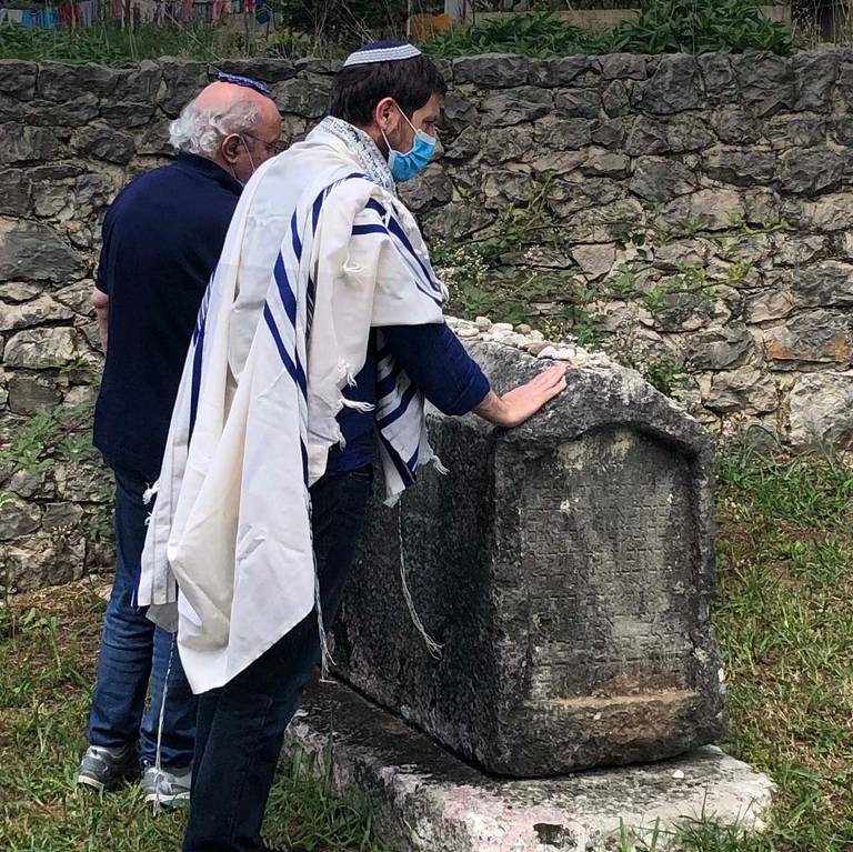 Igor Kozemjakin, right, at the grave of Rabbi Moshe Danon