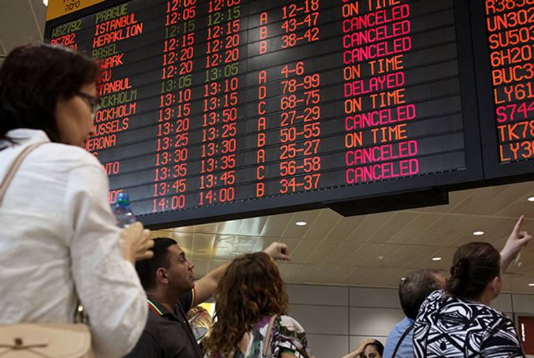 Passengers check a departure time flight board displaying various cancellations at Ben Gurion International airport, near Tel Aviv, on July 23, 2014. (GIL COHEN MAGEN/AFP/Getty Images)