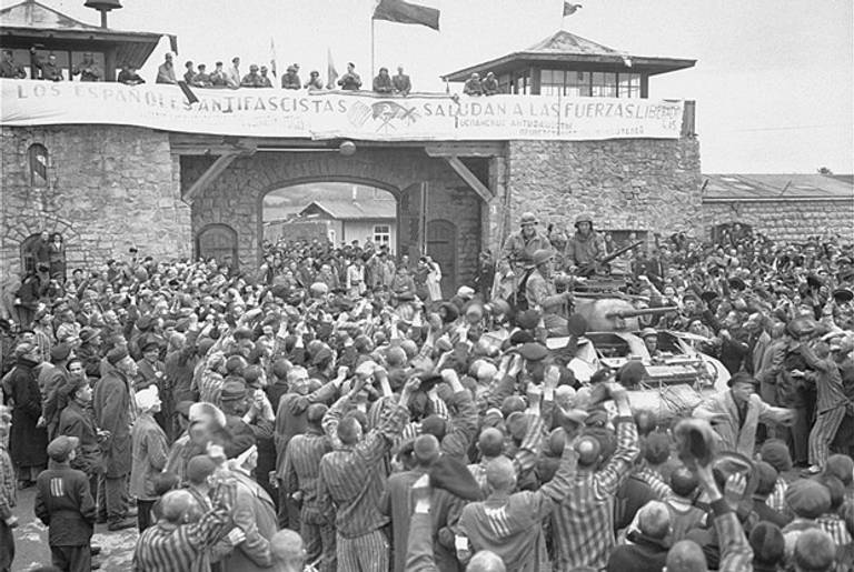 Mauthausen survivors cheer the soldiers of the Eleventh Armored Division of the U.S. Third Army one day after their actual liberation.(USHMM, courtesy of National Archives and Records Administration, College Park)