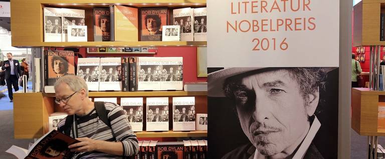 A man reads a book about Bob Dylan at the 2016 Frankfurt Book Fair in Frankfurt am Main, Germany, October 19, 2016. 