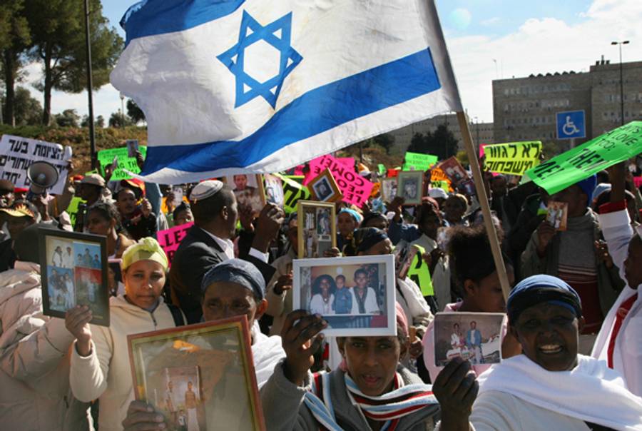 sraelis from the Ethiopian community hold up photographs of their relatives in front of Prime Minister Ehud Olmert's office in Jerusalem, 18 December 2007, during a demonstration against the government's decision to close down next week operation to bring Jewish Ethiopian to Israel.(GALI TIBBON/AFP/Getty Images)