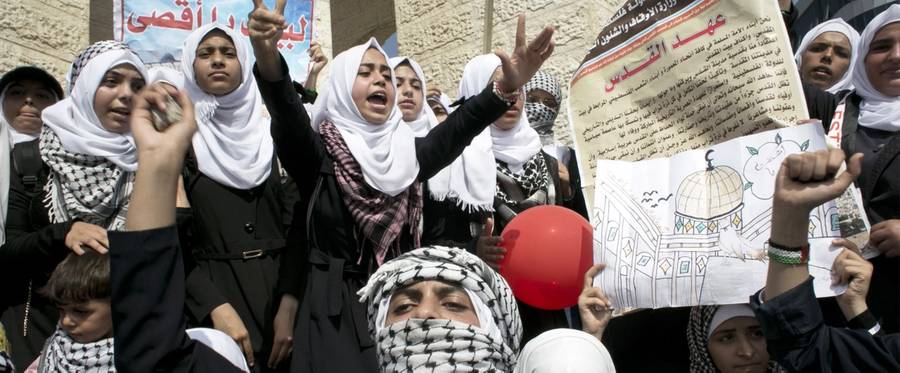 Palestinian schoolgirls, some wearing the trademark black-and-white keffiyeh, shout slogans during an anti-Israel protest in the southern Gaza Strip town of Rafah on October 14, 2015. Amid violent protests and a wave of stabbings spreading fear in Israel and warnings that a full-scale uprising could erupt, a new generation of Palestinians has been leading the unrest.