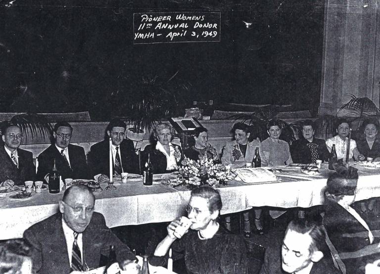 In the back row, Philip Birnbaum sits at far left, and the author's grandmother sits fifth from the right