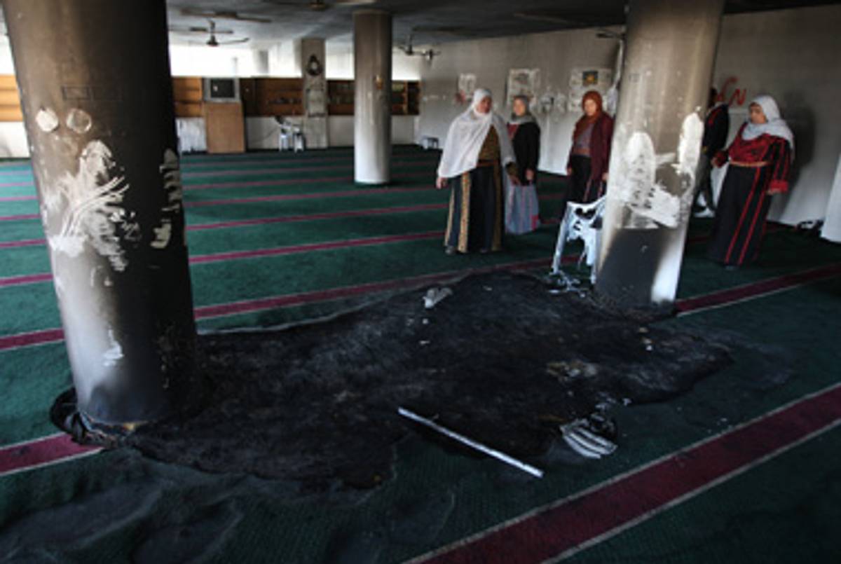 Palestinians survey a vandalized mosque yesterday.(Abbas Momani/AFP/Getty Images)