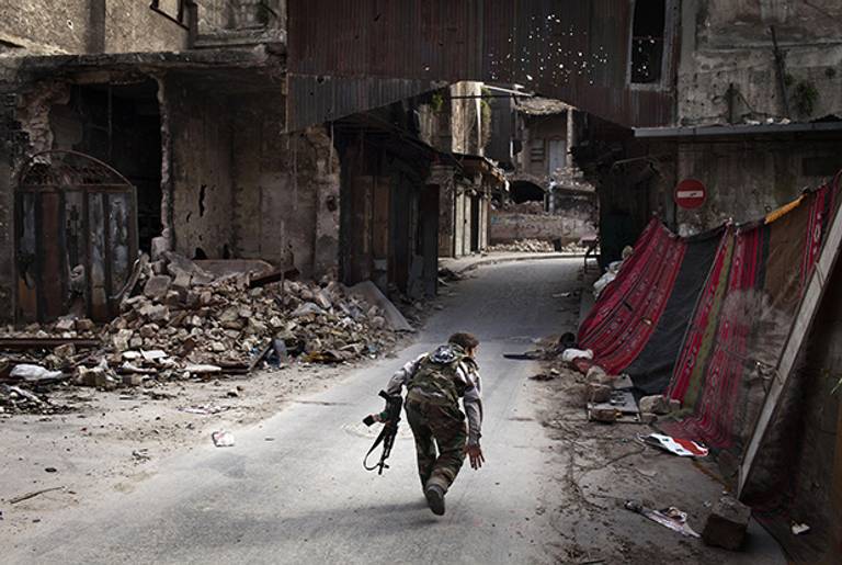A Syrian rebel crosses a street while trying to dodge sniper fire in the old city of Aleppo in northern Syria on March 11, 2013.(JM Lopez/AFP/Getty Images)