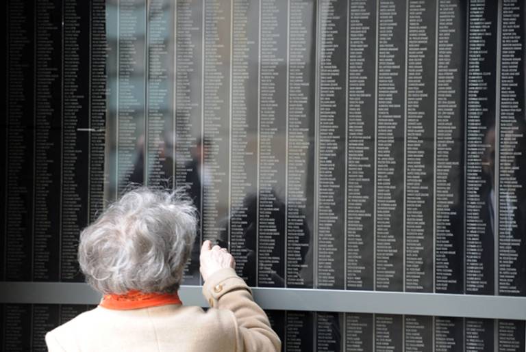 A local woman looks for her family member's name at the Holocaust Memorial Center in Budapest, where names and pictures of Hungarian victims have been displayed on April 16, 2012. (ATTILA KISBENEDEK/AFP/Getty Images)